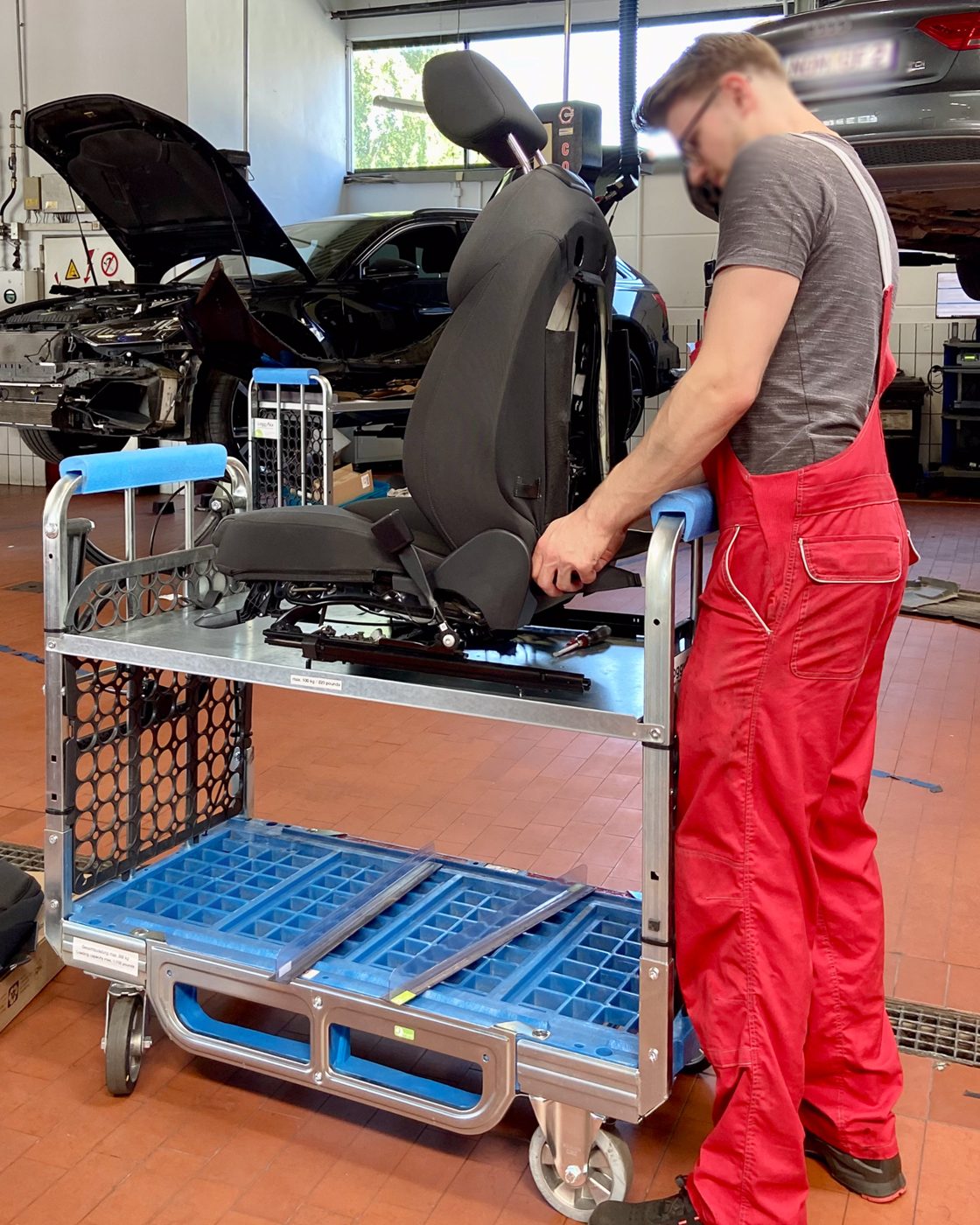 Mechaniker arbeitet an einem ausgebauten Fahrzeugsitz auf dem Loggyflex Duo mini