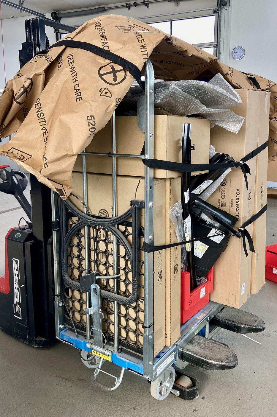 Loggyflex Standard mit Kartons und Verpackung im Lager, daneben ein Gabelstapler